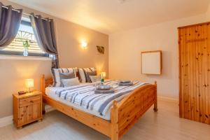 ein Schlafzimmer mit einem großen Holzbett und einem Fenster in der Unterkunft Ferienwohnung Airone Nero in Gerolstein