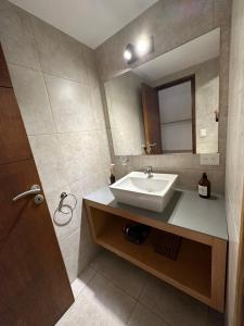 a bathroom with a sink and a mirror at Amplio departamento de diseño en el centro de SMA. 6C in San Martín de los Andes +18 photos