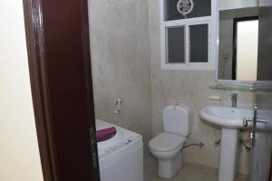 uma casa de banho com um WC branco e um lavatório. em Aknan 01 - Center Market em Salalah