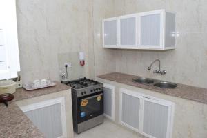 a small kitchen with a stove and a sink at Aknan Center Market in Salalah