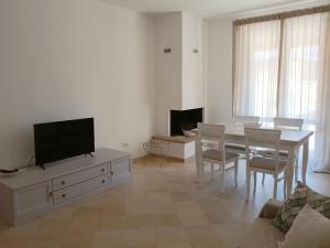 a white living room with a table and a tv at Casa Emilia - Appartamento per vacanze - Foligno in Foligno