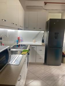 a kitchen with white cabinets and a black refrigerator at Sea retreat apartment in Himare