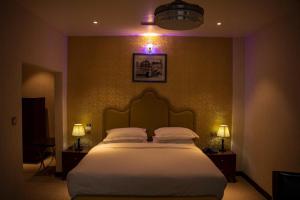 una camera da letto con un grande letto con due luci sul muro di RATNA HOTEL a Birātnagar