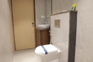 a bathroom with a toilet and a sink at LK GRAND HOME in Tirupati
