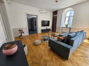 a living room with a blue couch and a tv at Apartament Sejmowa in Cieszyn