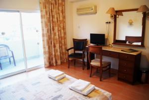 利馬索爾的住宿－M. 莫尼阿提斯酒店，客房设有一张带电脑和镜子的书桌