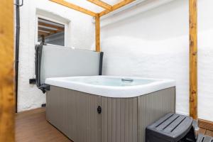 uma banheira sentada no meio de um quarto em The Cadnant Holiday House em Llandudno
