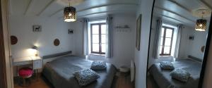 a bedroom with two beds and two windows at Maison au coeur du Sancy à la Tour d'Auvergne in La Tour-dʼAuvergne