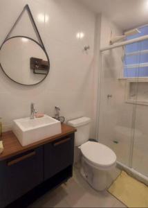 a bathroom with a sink and a toilet and a mirror at Studio da Babi in Rio de Janeiro
