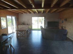 a living room with a couch and a table and chairs at Suite à la campagne dans une jolie maison en bois. in Laussonne