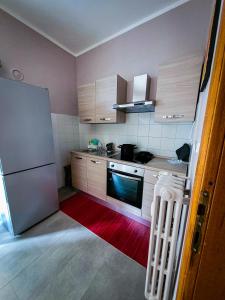 a small kitchen with a refrigerator and a red rug at Alloggio Rumore di Onde in Rapallo +10 photos