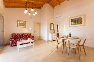 uma sala de estar com uma mesa e um sofá vermelho em Villa Ruby em Pesádha