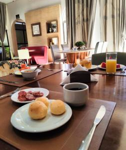 une table en bois avec des assiettes de nourriture dans l'établissement Imperial Palace Hotel Sorriso, à Sorriso