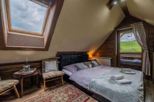 a bedroom with a bed and two chairs and a window at Vila Panorama in Ždiar