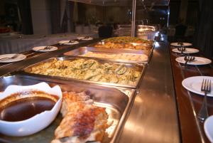 a buffet line of trays of food on a table at M. Moniatis Hotel in Limassol