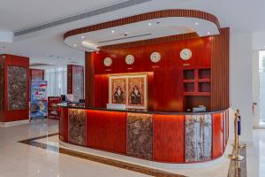 a lobby with a counter with clocks on the wall at Salalah International Hotel in Salalah