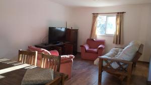 a living room with chairs and a tv and a table at Indigo in Carpintería