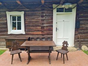a wooden table and chairs in front of a house at Morowo chałupa in Czchów