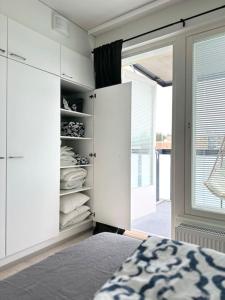 a bedroom with a bed and a closet with towels at Huoneisto juna aseman vieressä in Vantaa