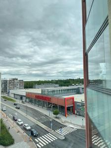 vistas a una calle de la ciudad con coches y un edificio en Huoneisto juna aseman vieressä en Vantaa