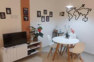 ein Wohnzimmer mit einem Tisch und einem TV sowie einem Tisch und Stühlen in der Unterkunft Studio da Babi in Rio de Janeiro