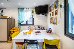 a dining room with a white table and yellow chairs at Boho House 2 in camp Terme Catez in Čatež ob Savi