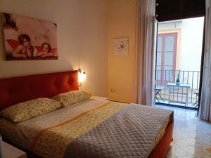 a bedroom with a bed and a view of a balcony at Sorrento City Center Atmosphere in Sorrento