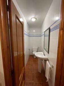 ein Badezimmer mit einem Waschbecken, einem WC und einem Spiegel in der Unterkunft Casa Nostra Matarranya in Calaceite