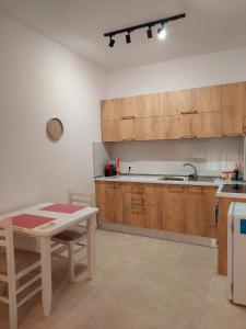 a kitchen with wooden cabinets and a table and a sink at Gex apartments in Tirana