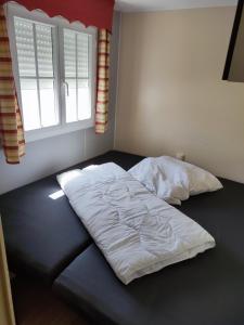 a bed with white sheets on it in a bedroom at Camping Urlaub Bredene Belgien in Bredene