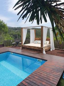 a bed on a deck next to a swimming pool at Montserrat Villa Deluxe Barcelona in Vacarisas