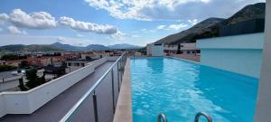 a swimming pool on the roof of a building with mountains at Apartman Mango & Mia in Trebinje