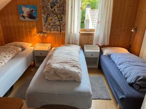 1 dormitorio con 2 camas y ventana en Bjørkely gård en Hidra