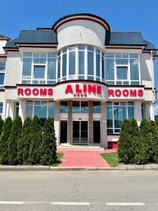 a red and white building with a tennis aline rooms sign at Garni Hotel Aline in Šabac