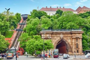 a large stone archway with people walking in front of it at Castle Chainbridge Apartment in Budapest