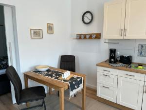 uma cozinha com mesa e cadeiras e um relógio em Martje em Lastrup