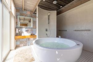 a white tub in a bathroom with a mirror at Cube house in Pärnu