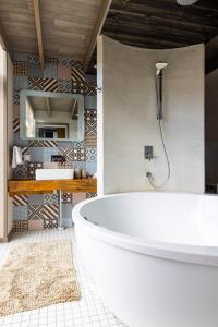 a bathroom with a large white tub and a mirror at Cube house in Pärnu