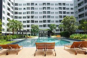 a swimming pool in front of a building at Elio Del Ray condo feel resort in Bangkok