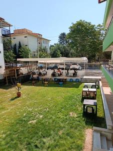 un parc avec des tables et des bancs dans une cour dans l'établissement Grand Atlas Pansiyon, à Pamukkale