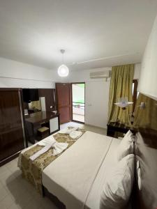- une chambre avec un grand lit et un bureau dans l'établissement Grand Atlas Pansiyon, à Pamukkale