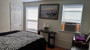 a bedroom with a bed and two windows at Beach Boutique Apartment in Old Orchard Beach