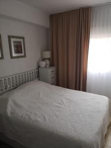 - une chambre avec un lit blanc et une fenêtre dans l'établissement Cerca del Mar, à Dénia