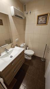La salle de bains est pourvue d'un lavabo blanc et de toilettes. dans l'établissement Cerca del Mar, à Dénia