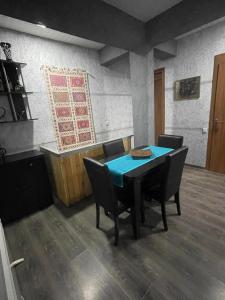 a dining room with a blue table and chairs at Cottage - Location Lanchvali in Mestia