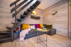 a living room with a couch and a staircase at Boho House 2 in camp Terme Catez in Čatež ob Savi