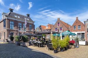 a street with tables and umbrellas in front of buildings at Appartement IJsselmeer Makkum strand in Makkum