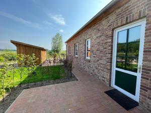 a brick building with a door and a patio at Fiete - a88177 in Lastrup