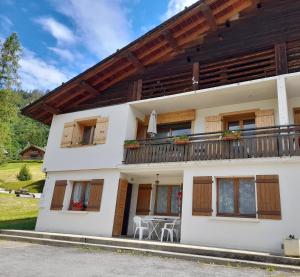 Casa con balcón y mesa en Les Granges, en La Clusaz