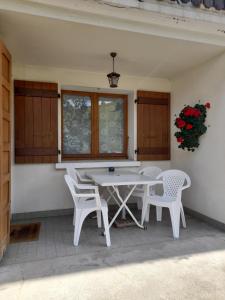 una mesa blanca y sillas en un patio en Les Granges en La Clusaz